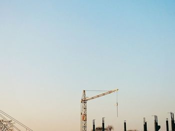 Low angle view of cranes against clear sky