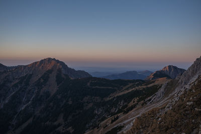 Scenic view of mountains against clear sky at sunset