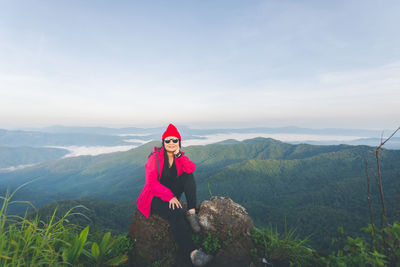 Portrait of young woman against mountains