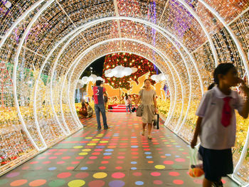 People in illuminated corridor