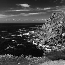 Scenic view of cliff by sea against sky