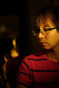 Close-up portrait of young man wearing eyeglasses at home