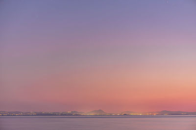 Scenic view of sea against clear sky at sunset