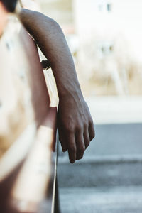 Cropped image of hand leaning out of car window