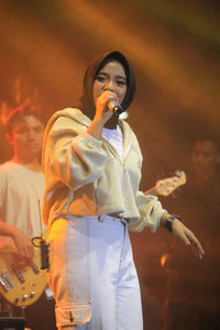 Portrait of young woman standing on stage