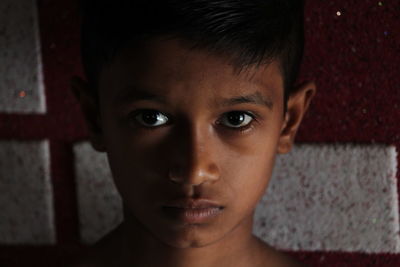 Close-up portrait of boy against wall