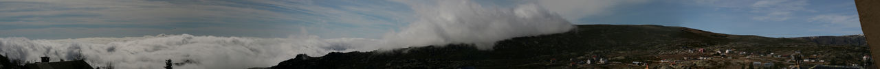 Scenic view of mountains against cloudy sky