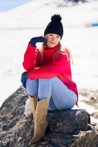 Portrait of young woman sitting on rock