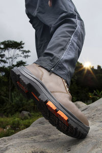 A man wears shoes on the rocks when camping and hiking