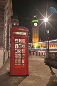 Illuminated clock tower in city at night