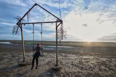 Rear view of man on beach against sky