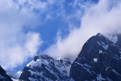 Low angle view of snowcapped mountains against sky