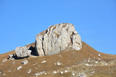 Rock formations on landscape against blue sky