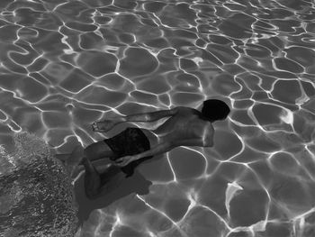 Rear view of man swimming in pool