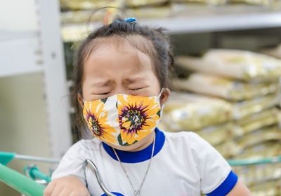 Girl wearing mask crying in supermarket