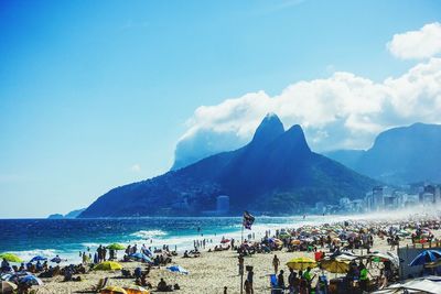 People on beach against blue sky