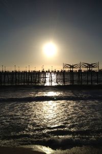 Silhouette pier over sea against clear sky during sunset