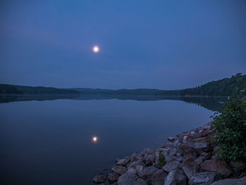 Scenic view of lake against sky at night