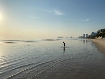 Child playing at sunrise at beach in early morning