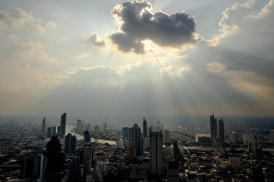 Aerial view of buildings in city against sky