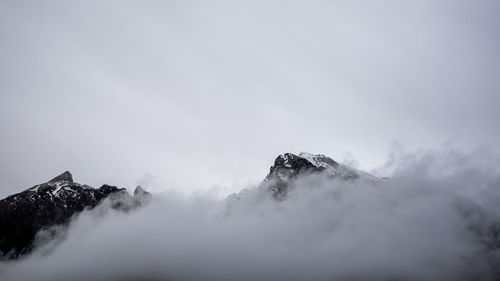 Low angle view of snowcapped mountains against sky