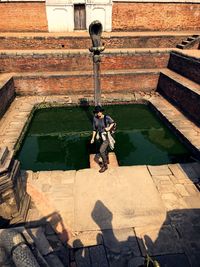 High angle view of woman standing by pond at bhaktapur