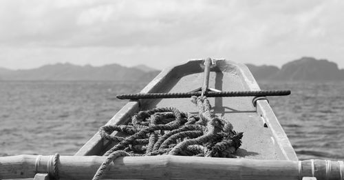 Close-up of rope tied on bollard against sky