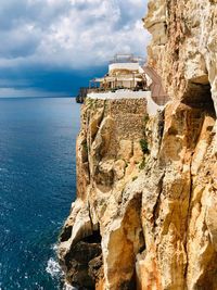 Rock formations by sea against sky