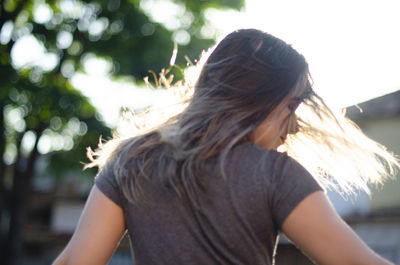 Rear view of woman standing against trees