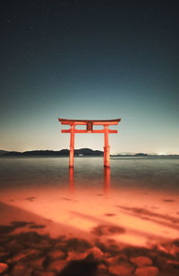 Lifeguard hut on beach against sky at night