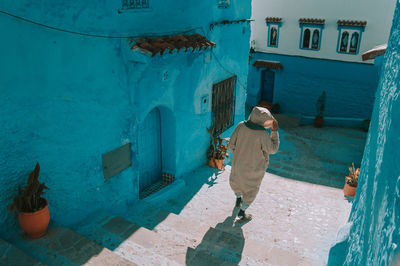 Rear view of man moving down on steps in town