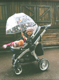 Rear view of woman with umbrella on road