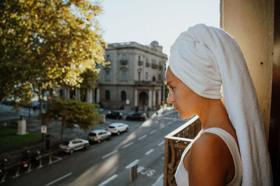 Woman standing on the balcony with bath towel