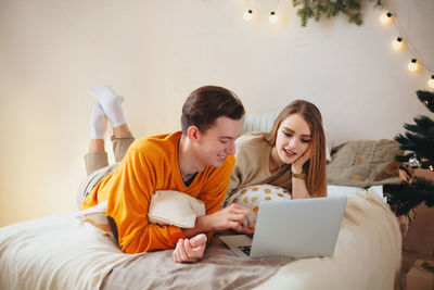 Young man using smart phone on bed