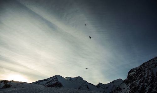 Low angle view of airplane flying over mountains