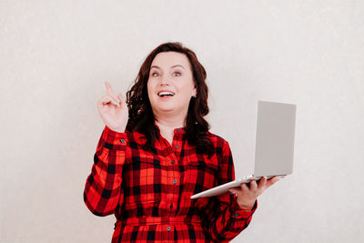 Young woman using mobile phone against white background