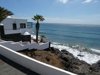 Scenic view of sea with villa against sky on sunny day