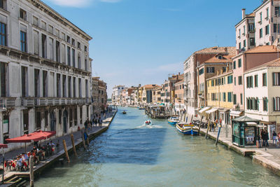 Moored boats in canal along built structures