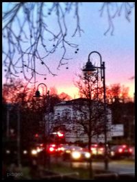 Road passing through city at sunset