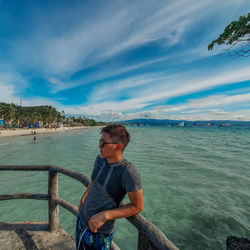 Boy standing on sea against sky