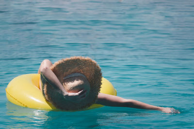 Woman relaxing in swimming pool against sea