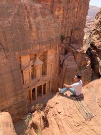 View of a woman sitting on rock