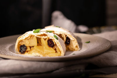 Close up of apple austrian strudel with cinnamon and mint on a plate