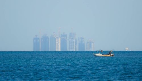 Sailboats in sea against clear sky