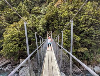 Woman on footbridge in forest