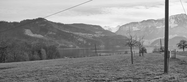 Scenic view of field by mountains against sky