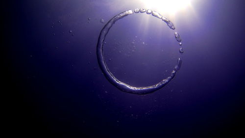 Close-up of bubbles in water against blue sky