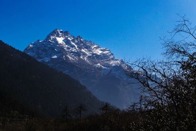 Scenic view of snowcapped mountains against clear blue sky