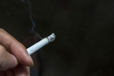 Close-up of hand holding cigarette