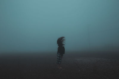 Rear view of man standing in foggy weather